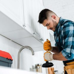 selective-focus-of-repairman-holding-plunger-in-ki-resize.jpg